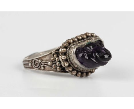 A Chinese silver and carved amethyst ring, designed as a Buddha within a beaded surround, with an expanding shank, weight 4.2