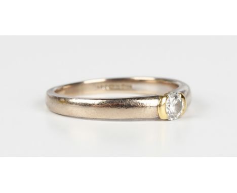 An 18ct two colour gold and diamond single stone ring, mounted with a circular cut diamond, detailed '.20', weight 3.4g, ring