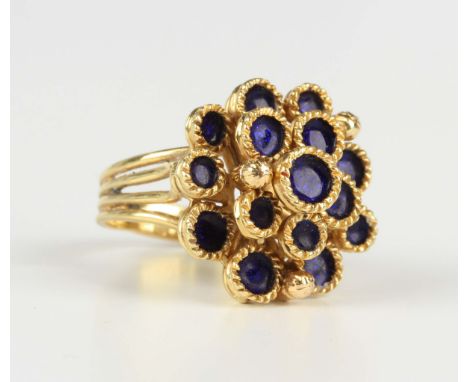 A gold and dark blue enamelled ring, designed as a series of roundels within ropetwist borders between wirework shoulders, de