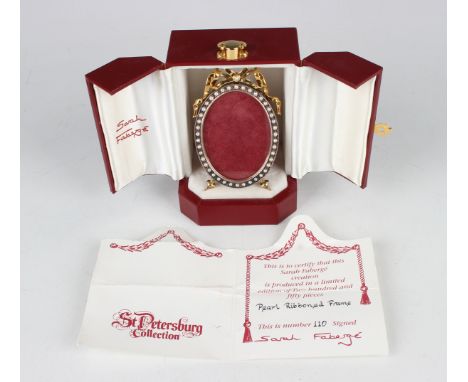 A Sarah Fabergé St Petersburg Collection silver and pearl mounted photograph frame of oval form with gilt ribbon bow surmount