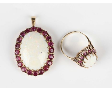 A 9ct gold, opal and ruby oval pendant, claw set with a large oval opal within a ruby set surround, London 1975, weight 8.4g,