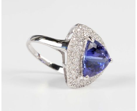 An 18ct white gold, tanzanite and diamond ring, claw set with a trilliant cut tanzanite within a diamond set surround, weight