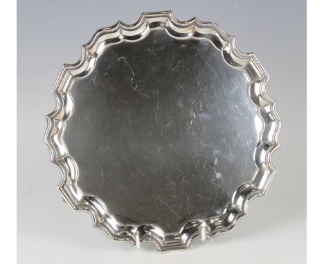 A George V silver circular card salver with raised piecrust rim, on scroll legs, Sheffield 1911 by Fordham &amp; Faulkner, we
