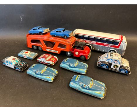 A tray of mostly Japanese tinplate including an SSS Automobile Carrier with two cars.