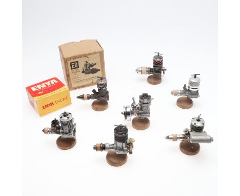 Eight various model engines including ED 246, Cokoa 2.5, Fok 25, Enya 3303, and other models. All mounted on wooden stands. (