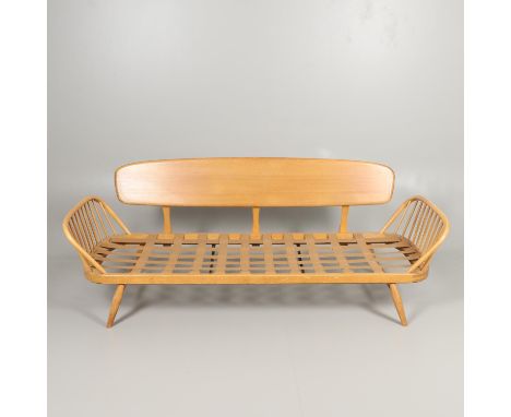 A vintage elm and beech day bed or couch, with a single plank back and spindle supports arms. With an Ercol label, some damag