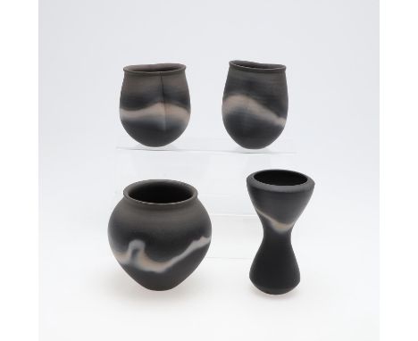 Four various stoneware vases with a black burnished glaze, one of waisted form (17.5cms high), two of flattened form (14.5cms