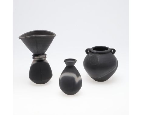 Three black burnished vases including a large vase of waisted form (25cms high), a small vase with incised line to each side 