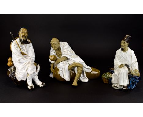 Three Oriental Figures A trio of earthenware figures each finished in white glaze, all in good condition. The first in the fo