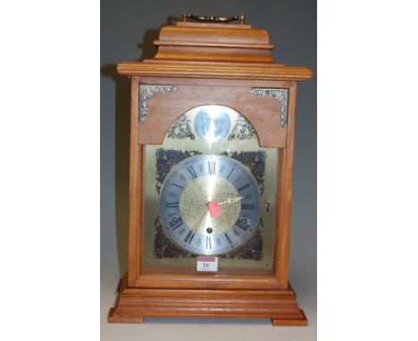 A reproduction continental oak cased bracket clock, having silvered chapter ring with Arabic numerals and three winding holes