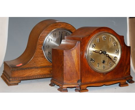 A 1920s oak cased mantel clock, having a silvered dial with Arabic numerals; together with a walnut cased example (2) 
