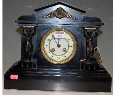 A late Victorian slate mantel clock of architectural form having an enamel dial with Arabic numerals