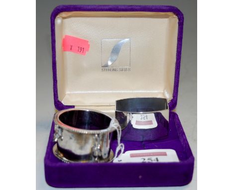 A modern silver napkin ring together with one other (2)