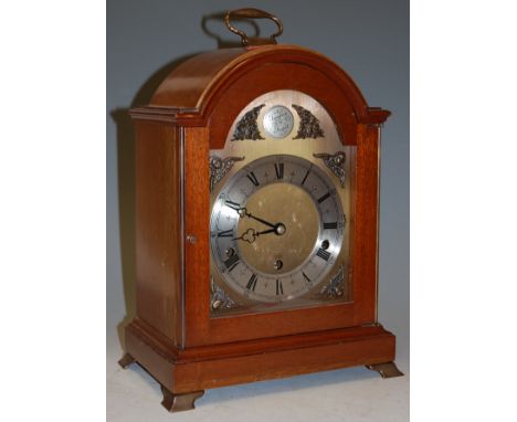 A reproduction mahogany cased bracket clock having a brass dial with silvered chapter ring and Arabic numerals, together with