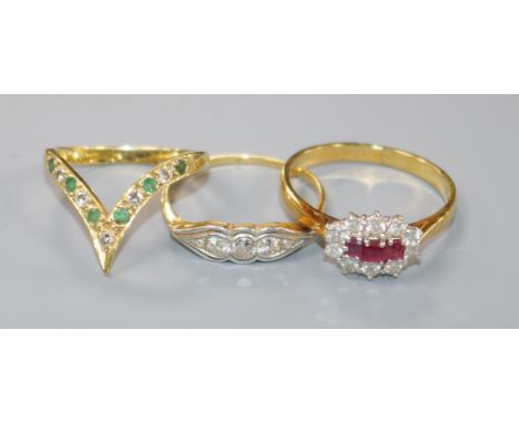 An 18ct gold, ruby and diamond cluster ring and two other 18ct gold rings, including a three-stone diamond ring and an eleven