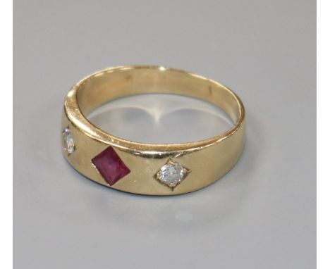 A yellow metal and gypsy set ruby and diamond three stone ring, size W.