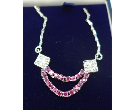 A white metal set diamond and ruby necklace