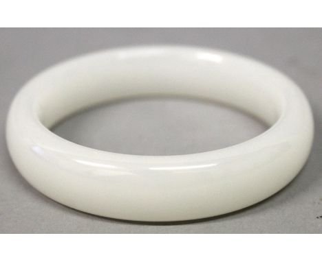 A CHINESE WHITE JADE-LIKE BANGLE, 3.1in diameter, the inner rim 2.3in diameter.