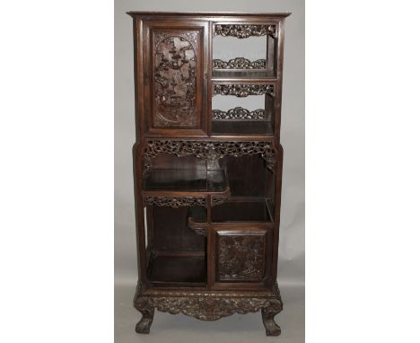 A TALL 19TH/20TH CENTURY CHINESE CARVED HARDWOOD DISPLAY CABINET, with two doors and a variety of staggered display shelves, 