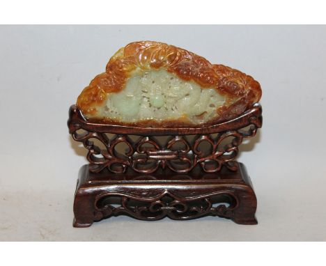 A CHINESE JADE-LIKE CELADON GREEN PLAQUE, together with a fitted wood stand, the centre with pierced decoration of a dragon a