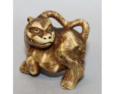 A GOOD JAPANESE MEIJI PERIOD STAG ANTLER NETSUKE OF A TIGER, its head turned backwards, its fur engraved and stained, 1.3in l