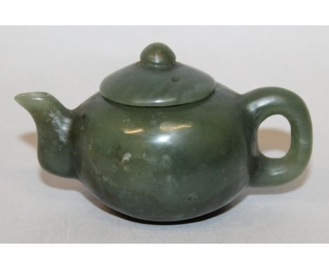 A MINIATURE CHINESE SPINACH GREEN JADE TEAPOT & COVER, the predominantly dark stone with some lighter inclusions, 3in long in