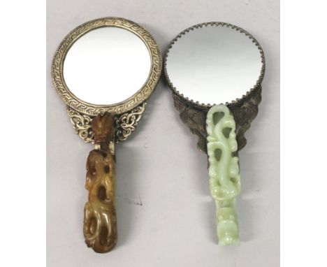 TWO EARLY 20TH CENTURY CHINESE EMBOSSED METAL MIRRORS WITH JADE BELT HOOKS, each belt hook of traditional form with a chilong