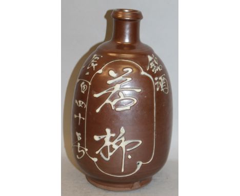 A 20TH CENTURY JAPANESE BROWN GLAZED CERAMIC FLASK, with character decoration reserved in white slip raised relief, 9.5in hig