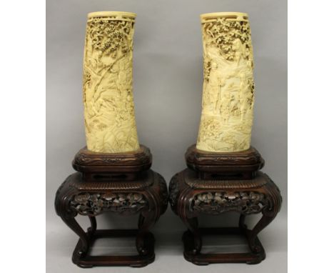 A LARGE PAIR OF FINE QUALITY JAPANESE MEIJI PERIOD CARVED IVORY TUSK VASES, each mounted on a fixed carved and pierced hardwo