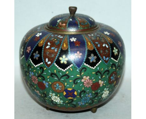 AN EARLY 20TH CENTURY JAPANESE CLOISONNE TRIPOD JAR & COVER, the sides decorated with flowerheads, leafage and roundels reser