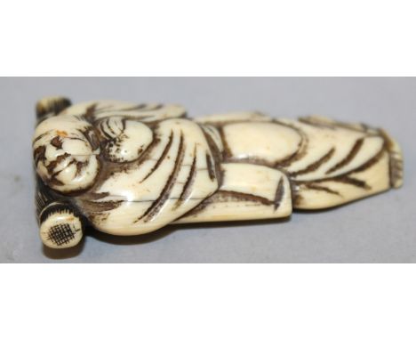 A GOOD 18TH/19TH CENTURY JAPANESE EDO PERIOD NETSUKE OF A SLEEPING TRAVELLER, carved to be used also as a brush rest, the man