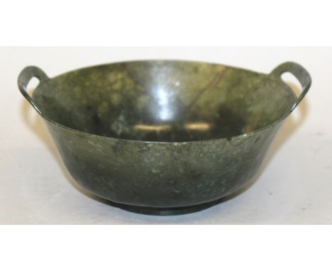 A CHINESE SPINACH GREEN JADE-LIKE BOWL, the rim with two pierced handles, 6.4in wide from handle to handle. 