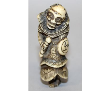 AN 18TH/19TH CENTURY JAPANESE CARVED IVORY NETSUKE OF A SENNIN, holding a drum and striker, 2.5in high.