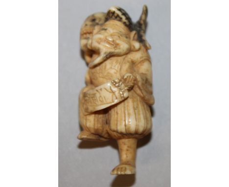 A 19TH/20TH CENTURY JAPANESE STAINED AND CARVED IVORY NETSUKE OF EBISU, standing on one leg with a giant carp carried on his 