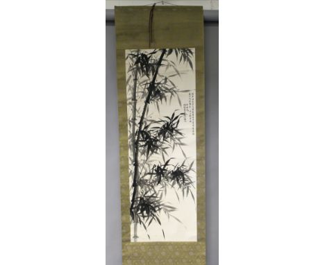 A CHINESE HANGING SCROLL PAINTING ON PAPER, within a patterned silk border, the painting depicting bamboo and with columns of