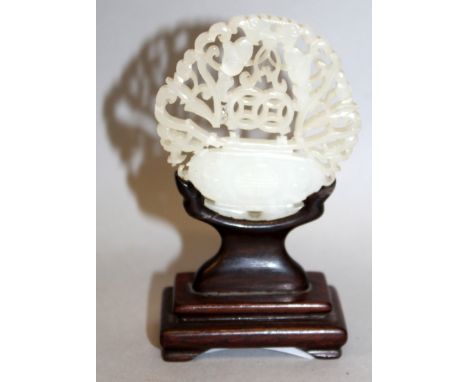 A 19TH/20TH CENTURY CHINESE PIERCED CELADON JADE PENDANT, together with a fitted wood stand, the jade carved and pierced in t