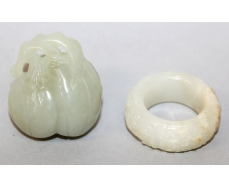 A CHINESE WHITE JADE-LIKE RING, with archaic decoration and russet inclusions, 1.4in diameter; together with a small celadon 