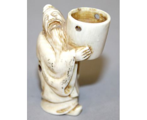 A SIGNED 19TH/20TH CENTURY JAPANESE CARVED IVORY NETSUKE OF A MAN HOLDING ALOFT A BUCKET, 2.1in high.