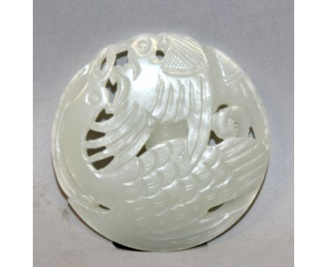 A CHINESE PIERCED CELADON GREEN PIERCED JADE CIRCULAR PENDANT, in the form of a pair of phoenix, 2in diameter. 