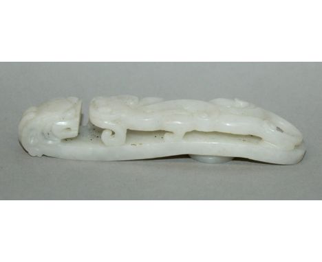 A CHINESE WHITE JADE-LIKE BELT HOOK, the stem pierced with a chilong, the hook in the form of a dragon’s head, 4.6in long. 