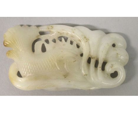 A CHINESE PIERCED WHITE JADE-LIKE MODEL, depicting a large fish swimming amidst lotus, 3.25in wide x 1.75in. 
