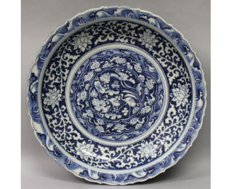 A CHINESE YUAN STYLE BLUE & WHITE PORCELAIN CHARGER, the interior decorated to its centre with a panel of wading storks, the 