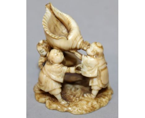 A GOOD QUALITY 19TH CENTURY SIGNED JAPANESE IVORY NETSUKE OF A GROUP OF BOYS, two of the boys holding up a large conch shell,