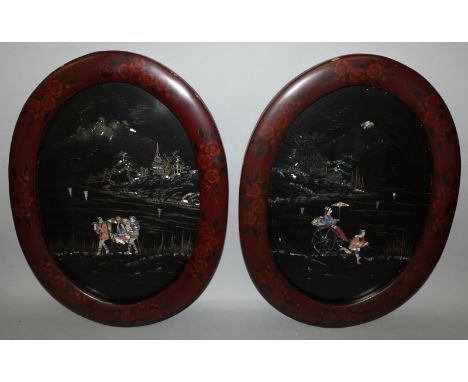 A PAIR OF EARLY 20TH CENTURY JAPANESE OVAL MOTHER-OF-PEARL INLAID LACQUER PANELS, each in a floral decorated red lacquer fram