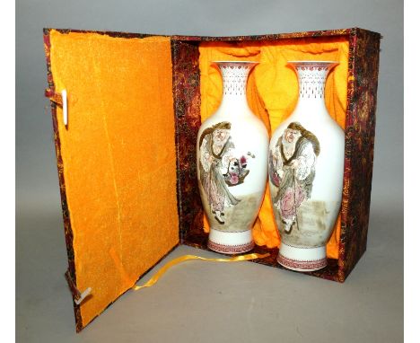 A MIRROR PAIR OF CHINESE PORCELAIN VASES, together with a fitted box, each vase painted with a bearded elderly man bearing a 