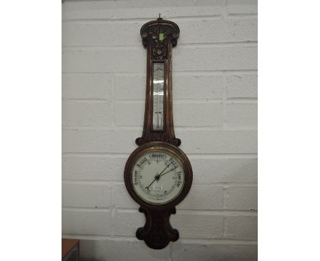 An Edwardian oak cased banjo aneroid barometer, having thermometer scale