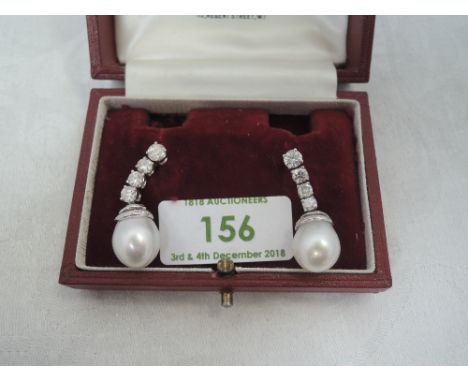 A pair of south sea cultured pearl and diamond drop earrings, each pearl approx 11mm diameter with a tiered diamond chip set 