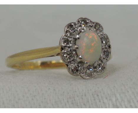 A lady's dress ring having an opal and diamond cluster in a raised claw illusionary setting approx 0.25ct diamonds and 0.5ct 