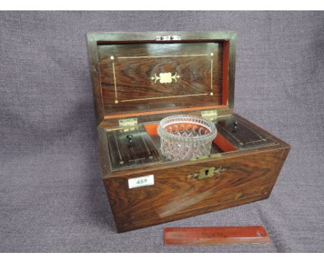 An early 19th century rosewood tea caddy of sarcophagus shape having brass inlay and fitted interior