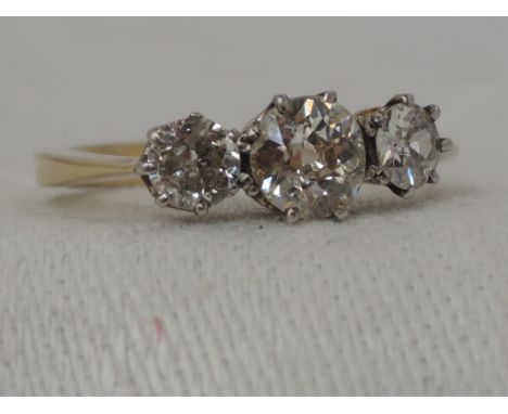 A lady's dress ring having a trilogy of diamonds approx 1.25ct total in a claw setting to knife blade shoulders on a yellow m